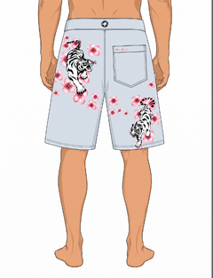A digital mockup of a model wearing light blue board shorts with white and black tiger prints and pink cherry blossoms, shown from the back against a white background.
