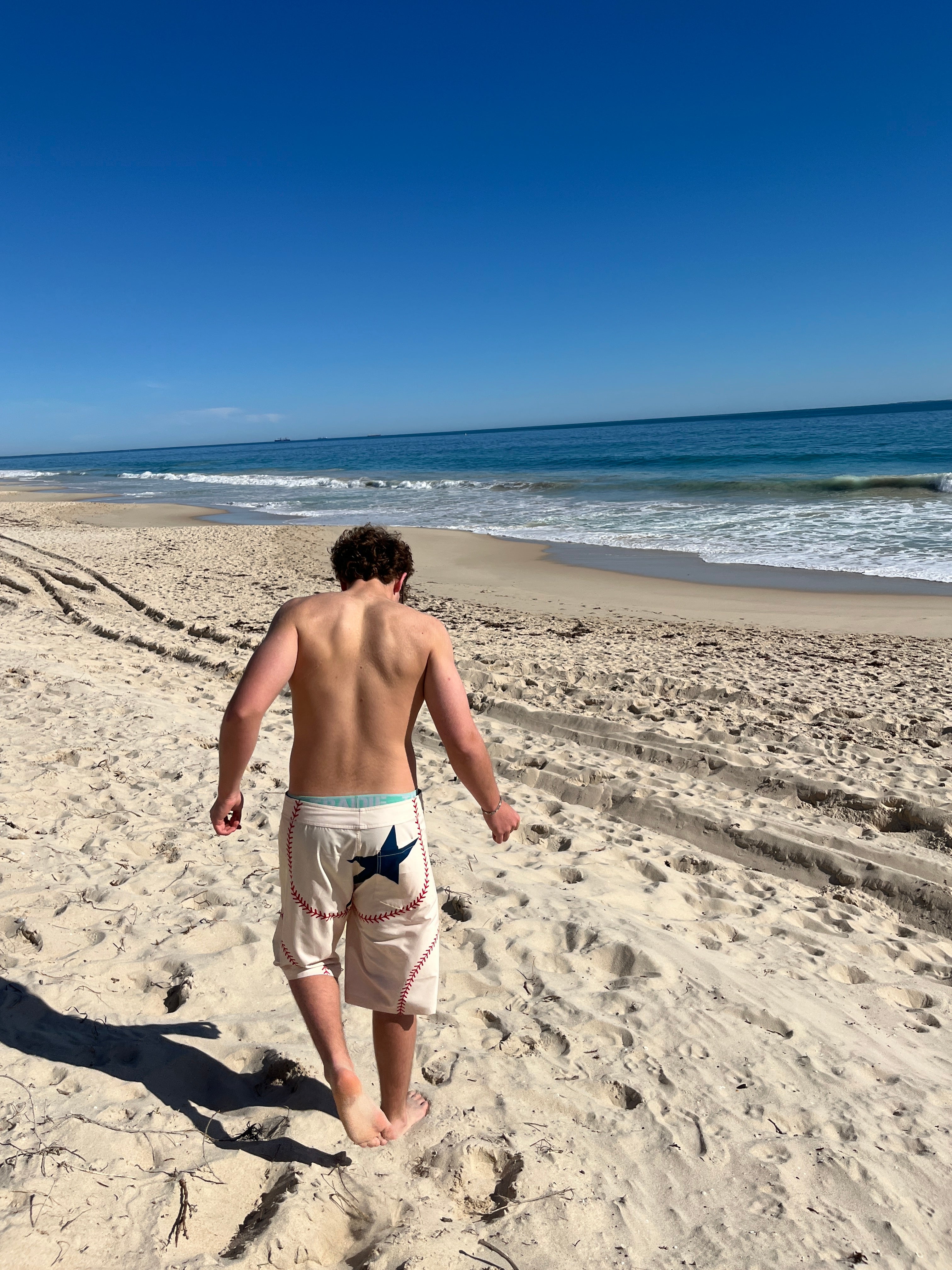Walking down the beach in HOMERUN board shorts