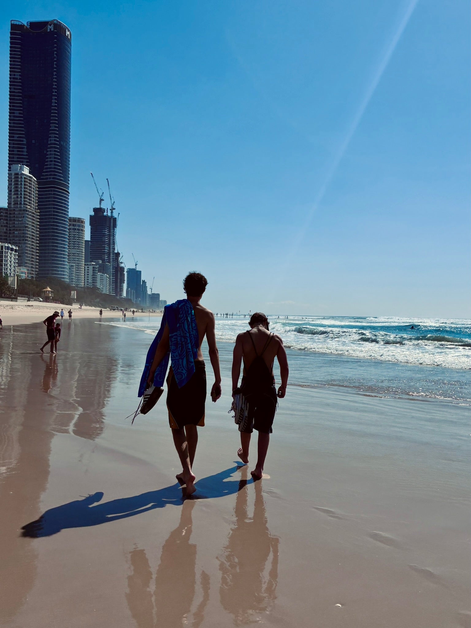 Two people walking along a Gold Coast beach